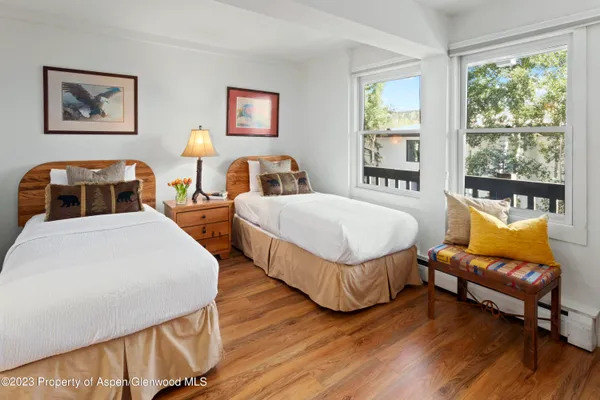 a bedroom with two beds and a large window