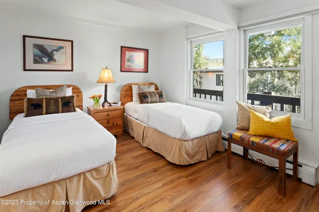 a bedroom with two beds and a large window