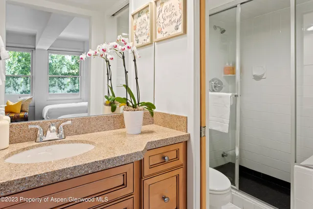 a bathroom with a granite countertop sink and a mirror