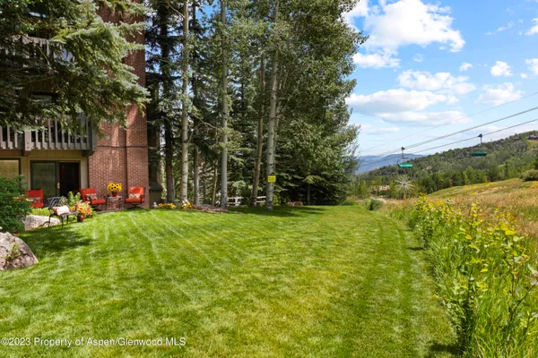 a view of a swimming pool and lounge chairs in back yard of the house