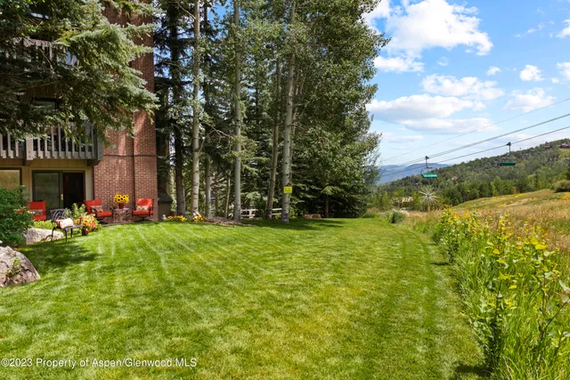 a view of a swimming pool and lounge chairs in back yard of the house