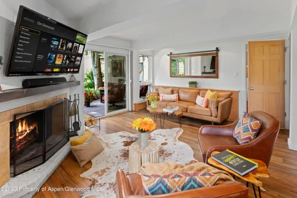 a living room with furniture a flat screen tv and a fireplace