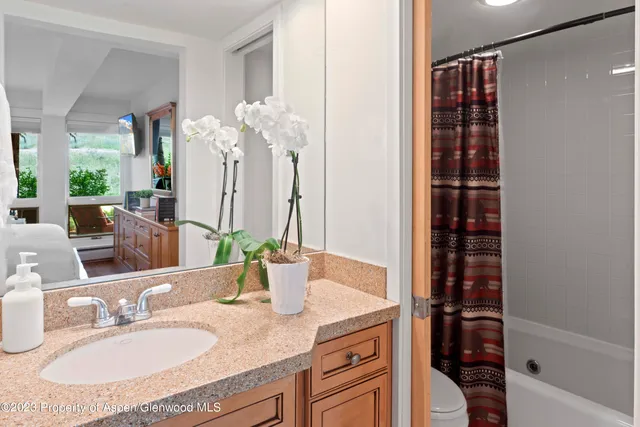 a bathroom with a granite countertop sink a toilet and shower