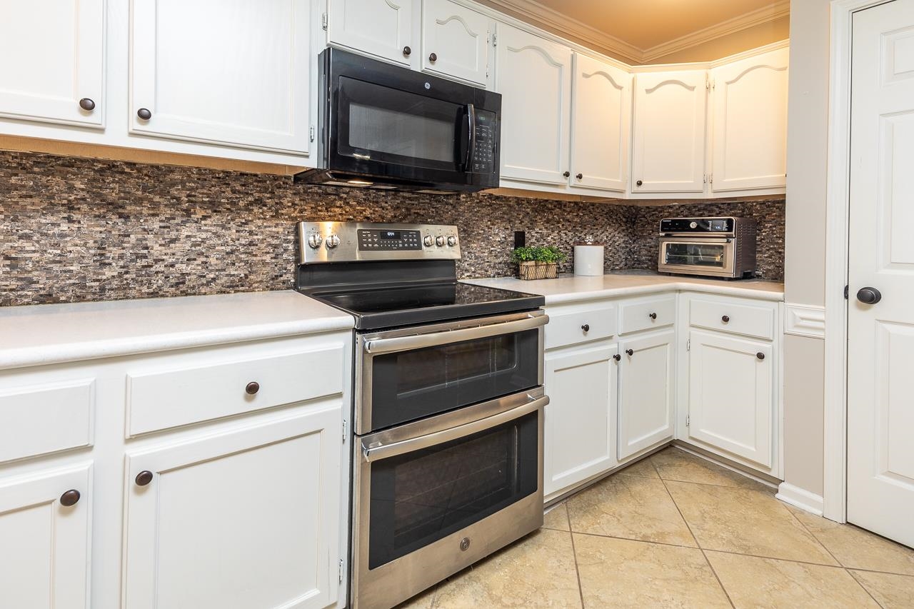905 Grapevine Drive Collierville, TN 38017 - Photo 12 of 25 a kitchen with granite countertop white cabinets and appliances