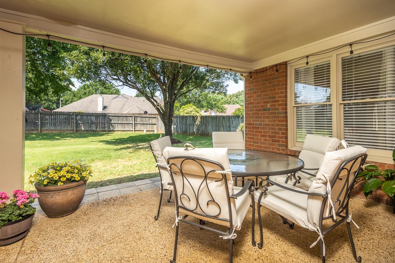 905 Grapevine Drive Collierville, TN 38017 - Photo 24 of 25 a view of a patio with table and chairs potted plants and floor to ceiling window