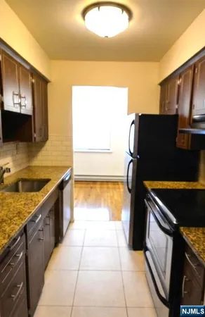 a kitchen with granite countertop a stove a sink and a microwave
