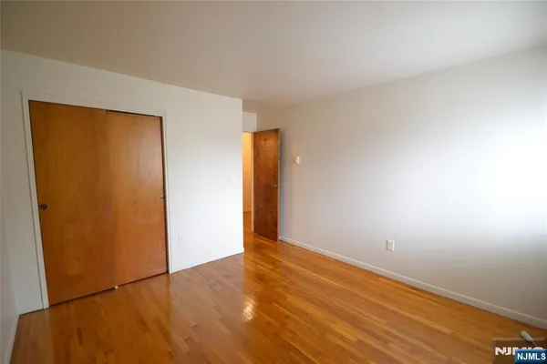 an empty room with wooden floor and closet