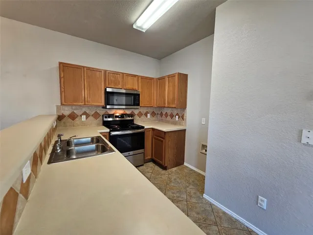 a kitchen with sink a microwave a stove and refrigerator