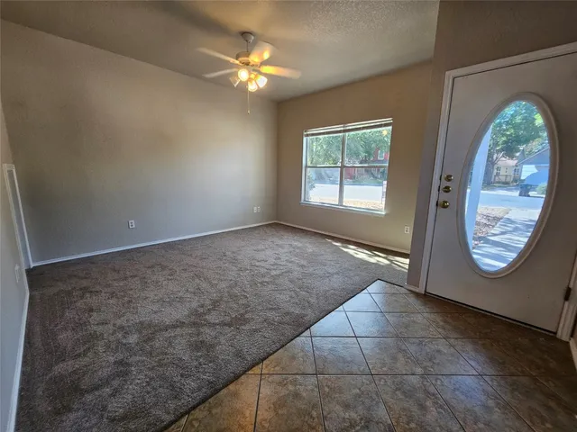 an empty room with windows and fireplace
