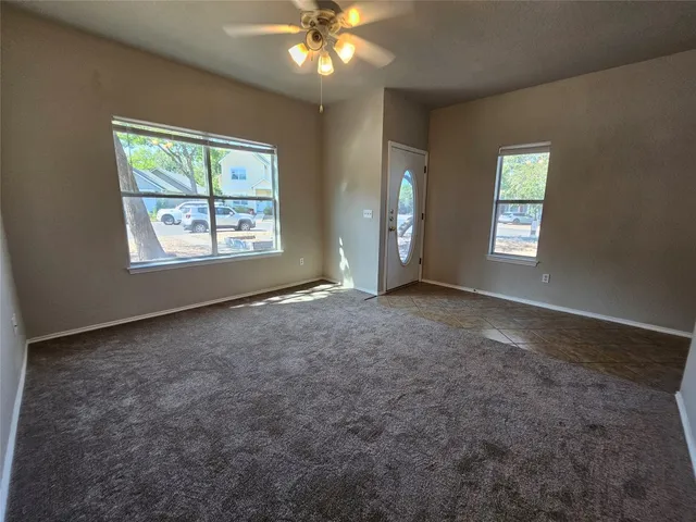 an empty room with windows and mirror fan