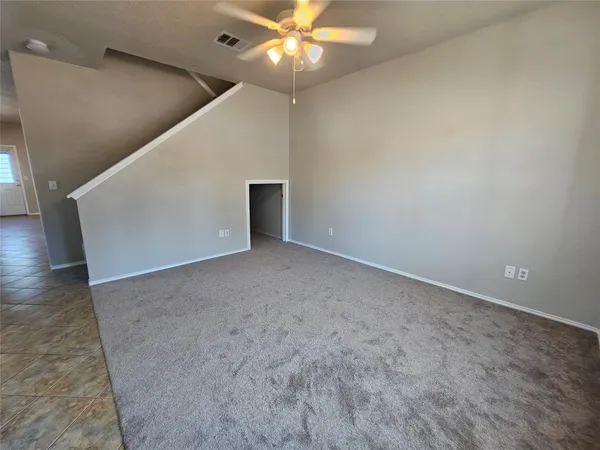 en empty room with wooden floor and ceiling fan