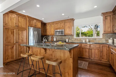a kitchen with stainless steel appliances granite countertop a refrigerator sink and cabinets