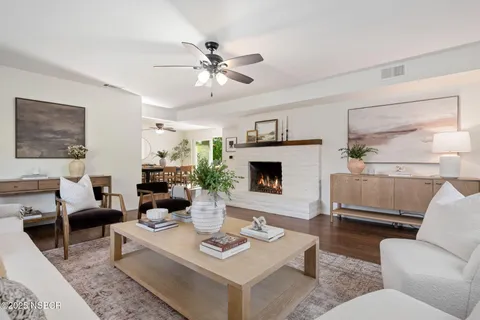a living room with furniture a fireplace and a large window