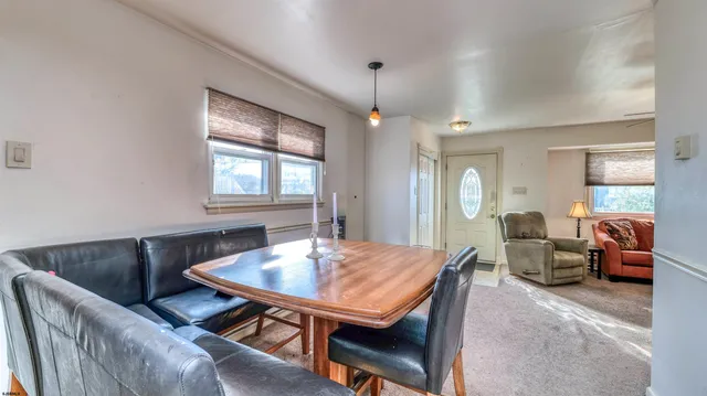 a view of a roof deck with table and chairs under an umbrella with wooden floor