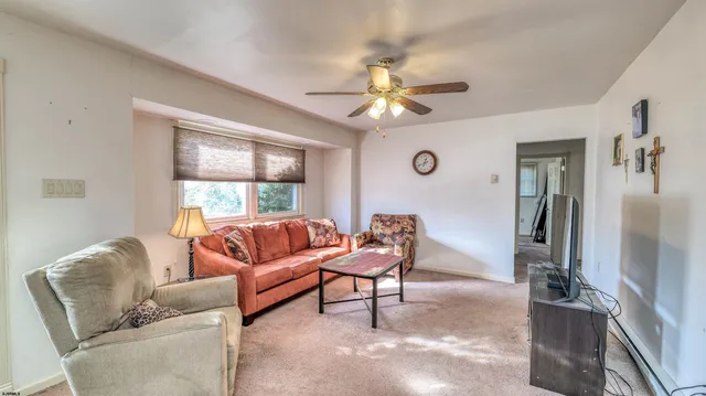a living room with furniture a ceiling fan and a window