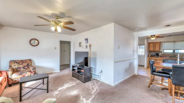 a living room with furniture and kitchen view