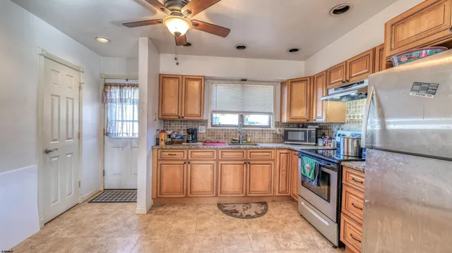 a kitchen with stainless steel appliances granite countertop a refrigerator and a stove top oven
