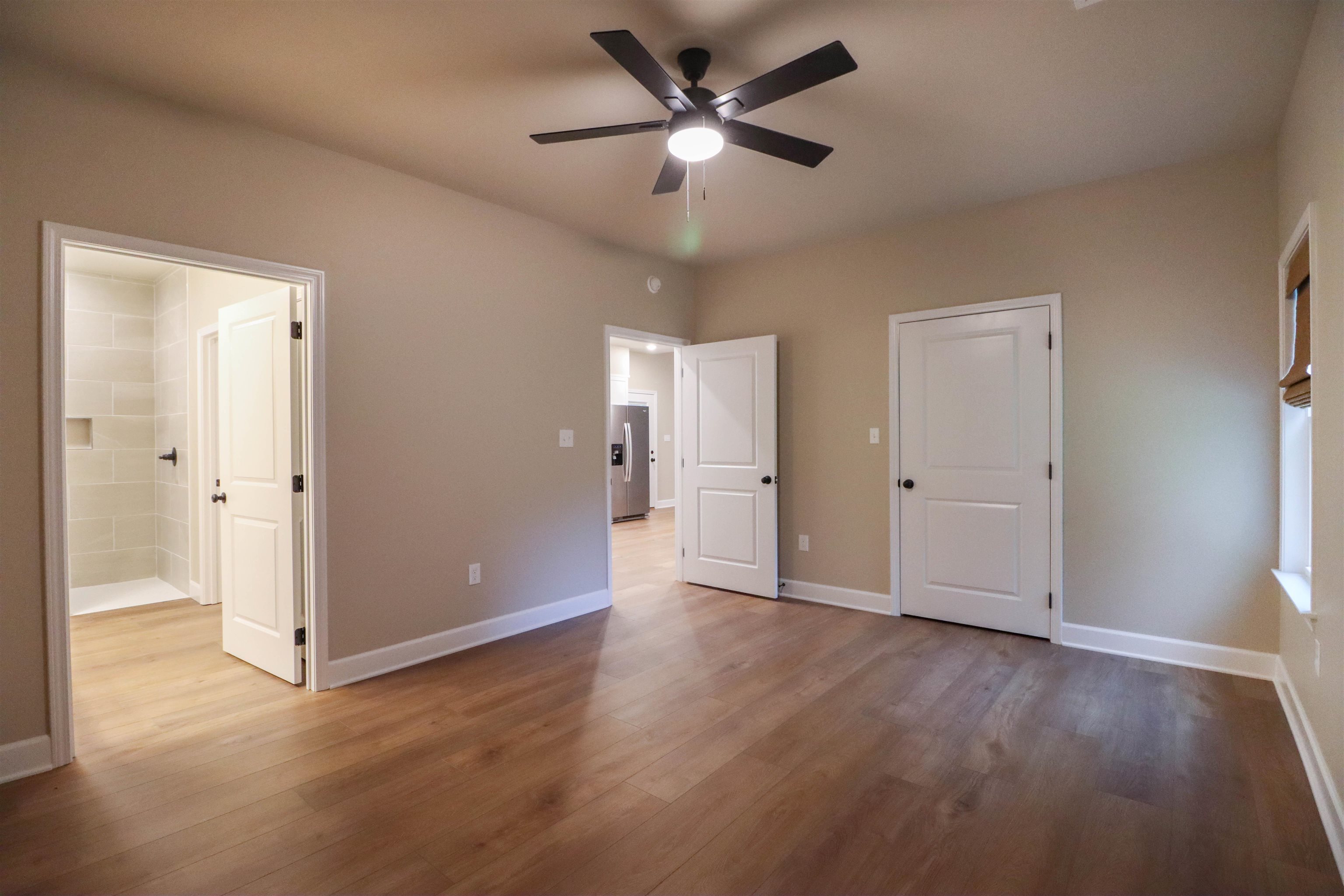 208 Church Street Ripley, TN 38063 - Photo 10 of 33 Primary Bedroom featuring luxury vinyl floors, ceiling fan and ensuite bath.