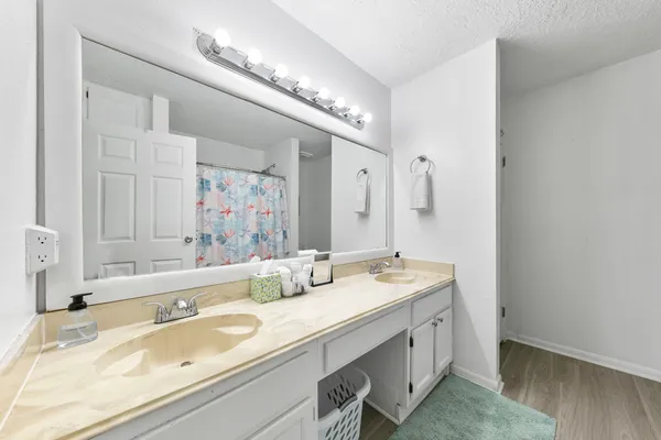 a bathroom with a granite countertop sink and a large mirror