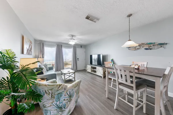 a dining room with furniture a chandelier and wooden floor