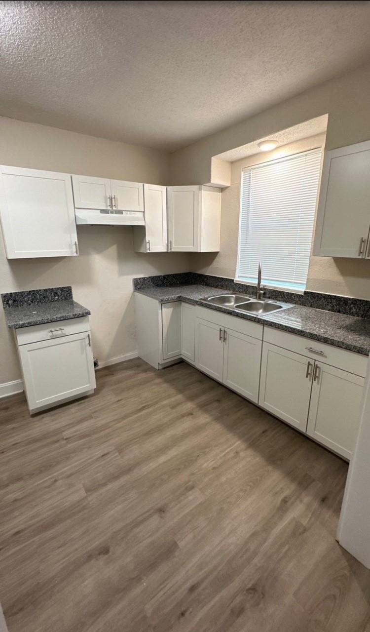 3333 Farmville Road Memphis, TN 38122 - Photo 6 of 12 a kitchen with stainless steel appliances granite countertop a stove a sink and white cabinets with wooden floor
