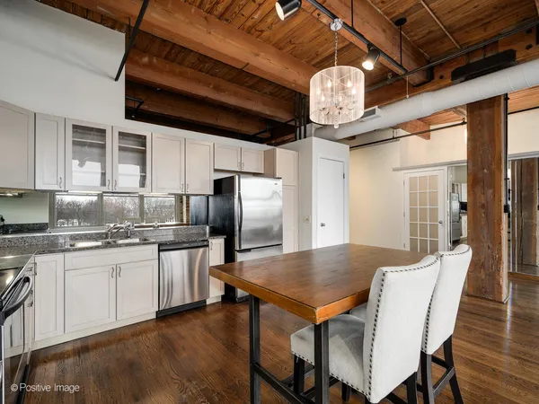 a kitchen with stainless steel appliances granite countertop a kitchen island a table and chairs