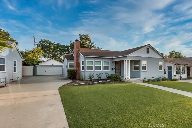a front view of a house with a yard and trees