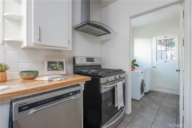 a kitchen with stainless steel appliances granite countertop a stove and a white refrigerator