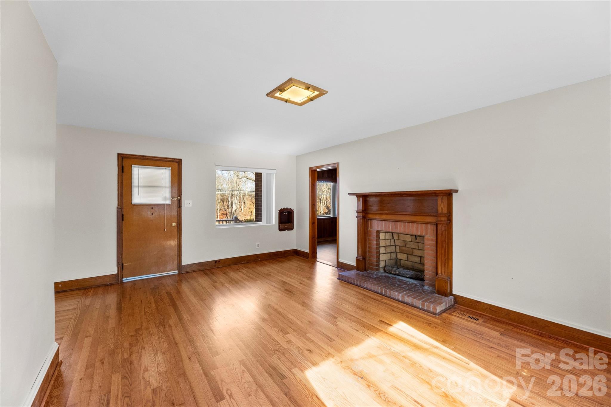 845 St Marks Church Road Cherryville, NC 28021 - Photo 13 of 47 an empty room with a fireplace and wooden floor