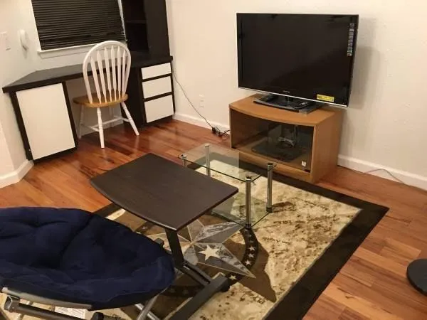 a living room with chair and a flat screen tv