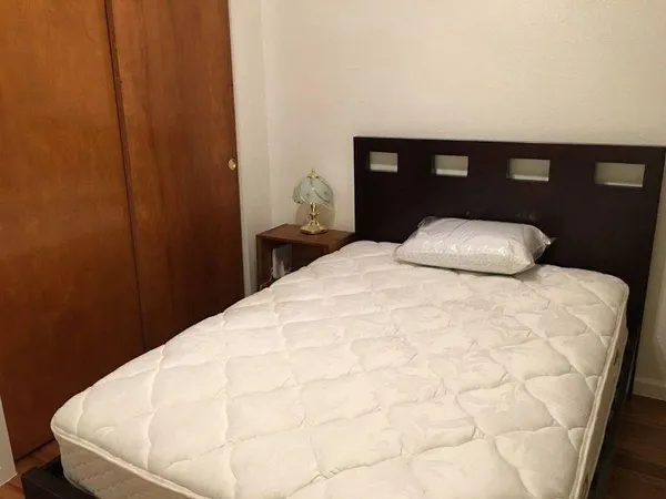 a large bed sitting in a bedroom next to a window