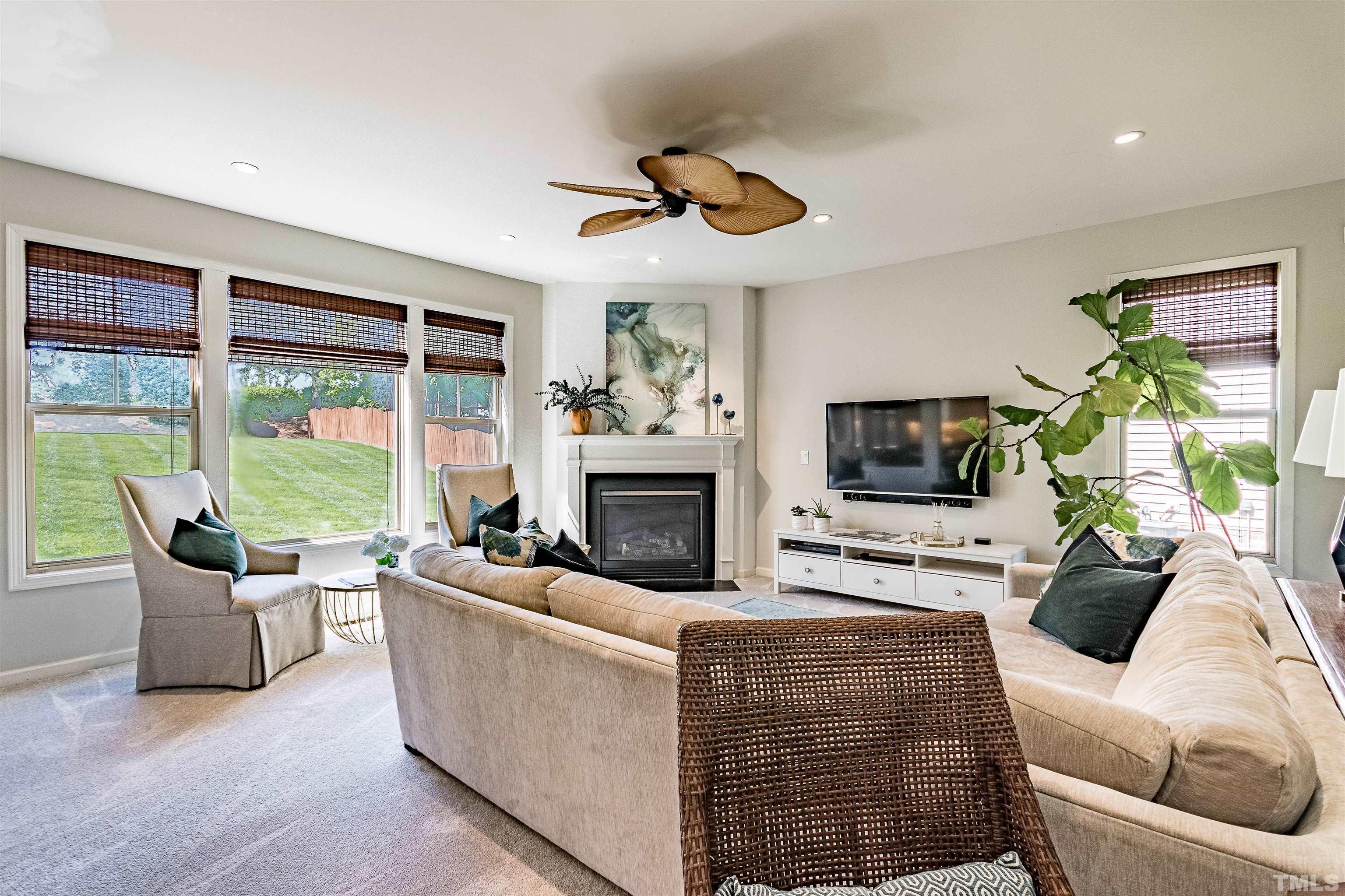 9009 Cornwell Drive Wake Forest, NC 27587 - Photo 12 of 36 a living room with furniture a fireplace and a floor to ceiling window