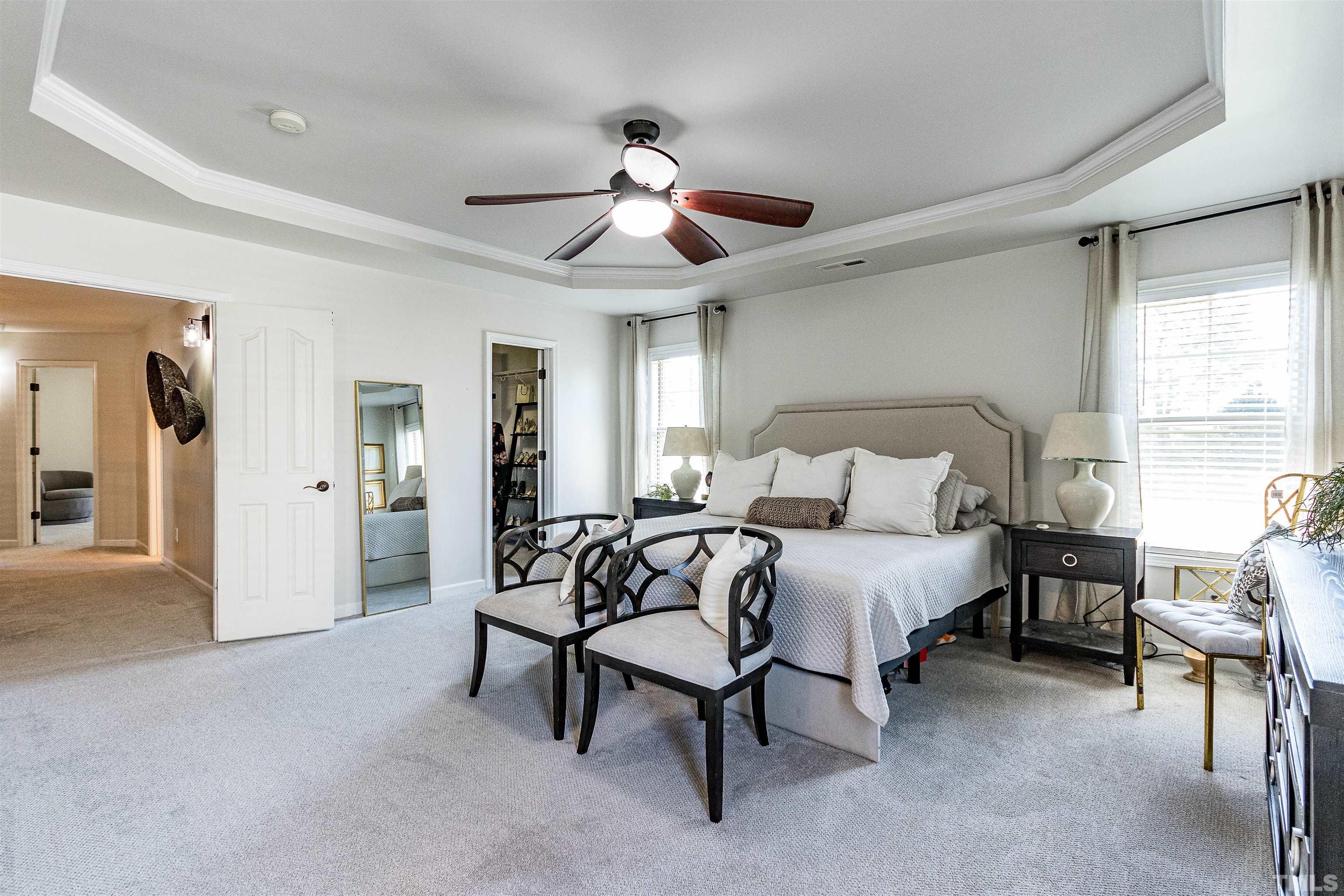 9009 Cornwell Drive Wake Forest, NC 27587 - Photo 25 of 36 a spacious bedroom with a bed and a chandelier