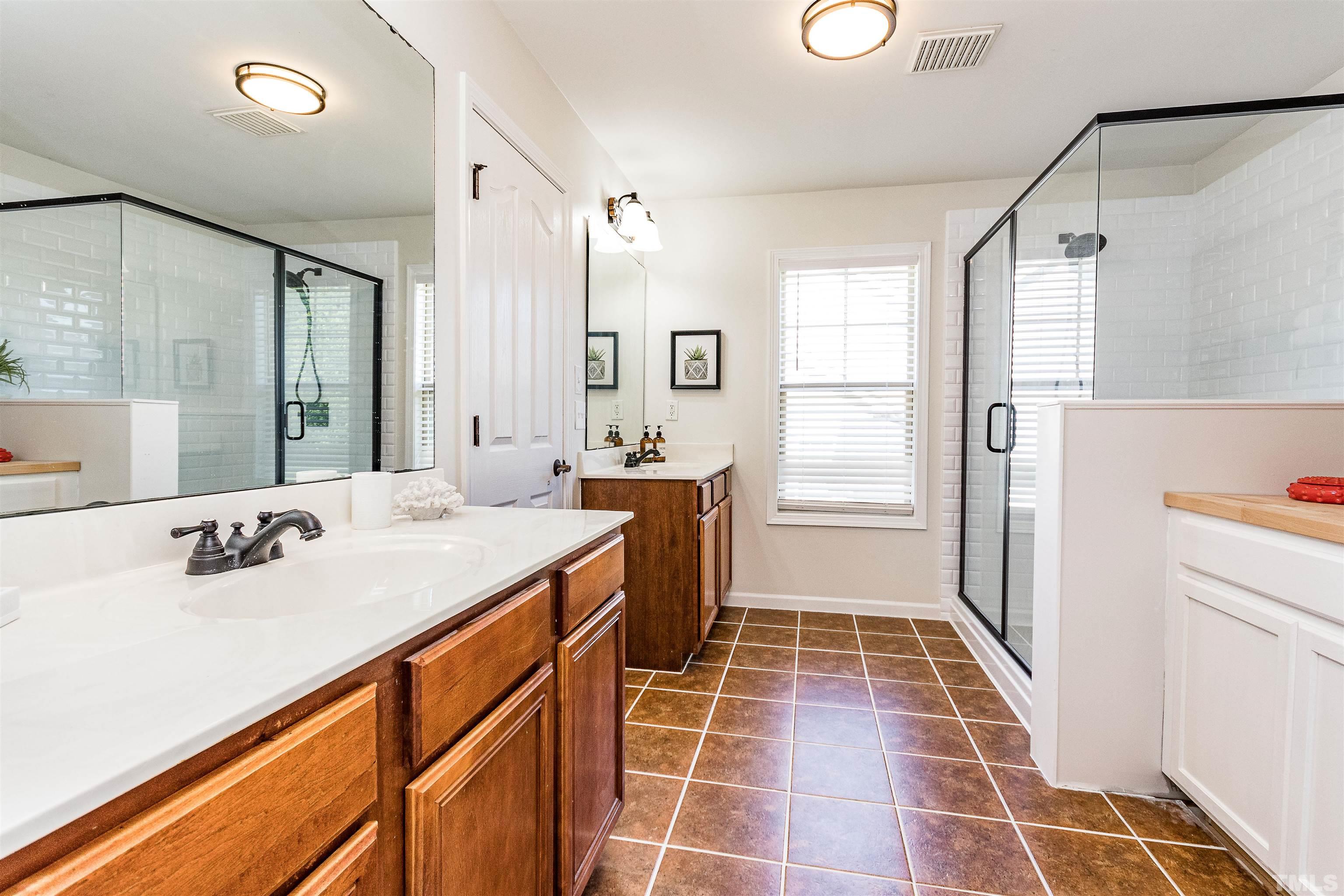 9009 Cornwell Drive Wake Forest, NC 27587 - Photo 27 of 36 a bathroom with a sink toilet double vanity and tub