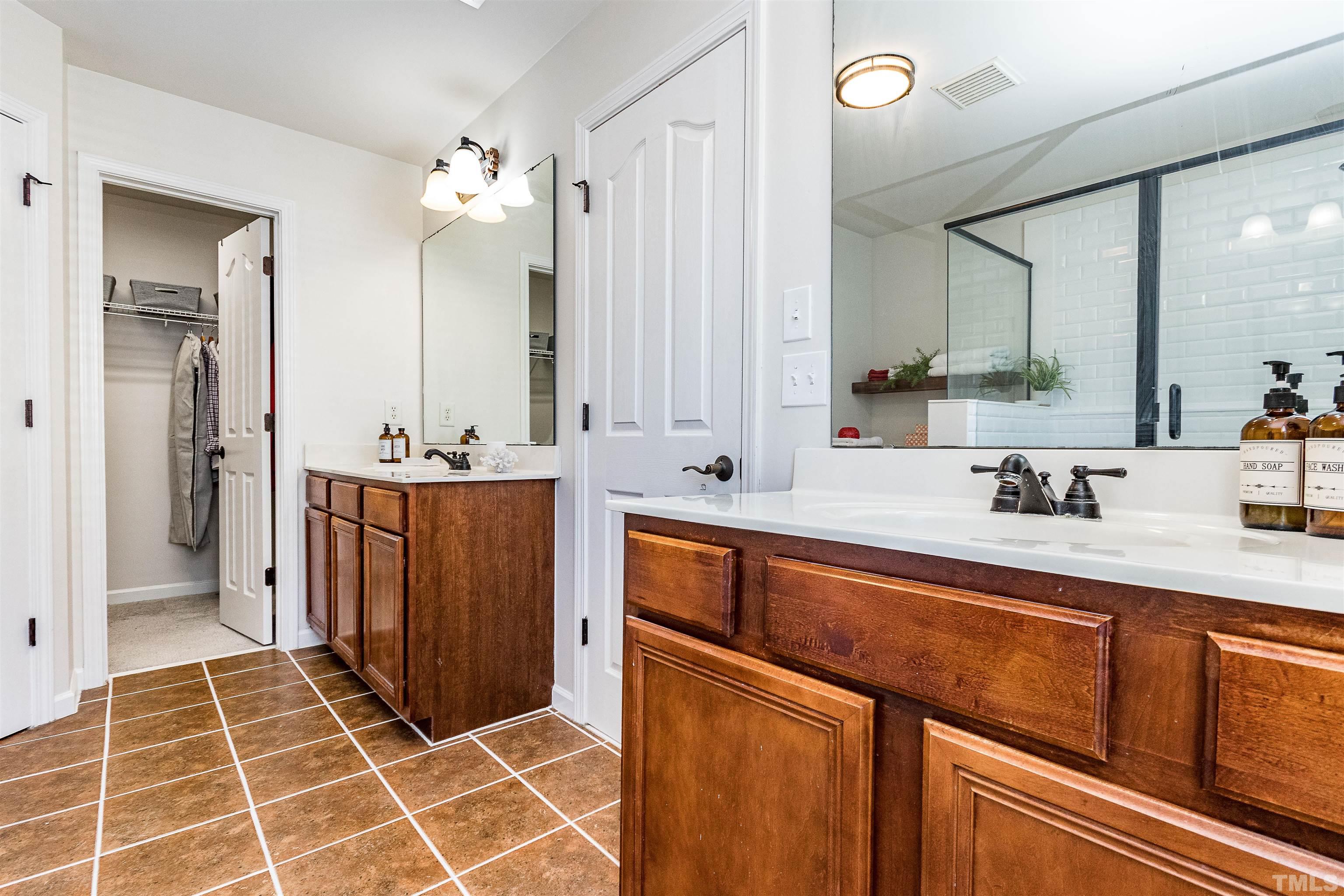 9009 Cornwell Drive Wake Forest, NC 27587 - Photo 29 of 36 a spacious bathroom with a shower sink and mirror
