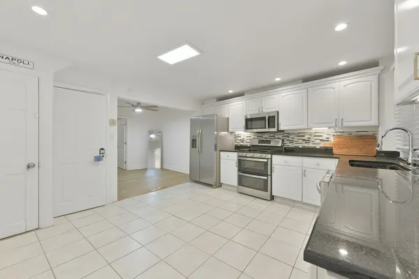 a kitchen with stainless steel appliances granite countertop a stove a sink and a refrigerator