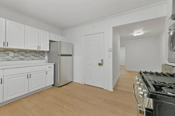 a kitchen with white cabinets and white appliances