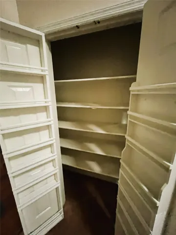 a view of walk in closet with empty racks