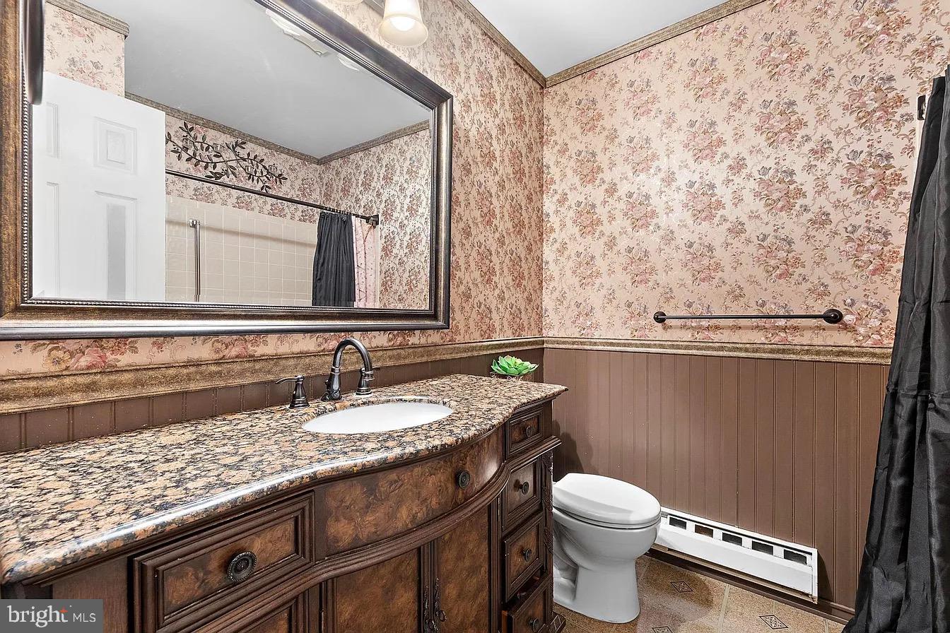 22 Fir Road Manahawkin, NJ 08050 - Photo 27 of 35 a bathroom with a granite countertop sink a toilet and a mirror