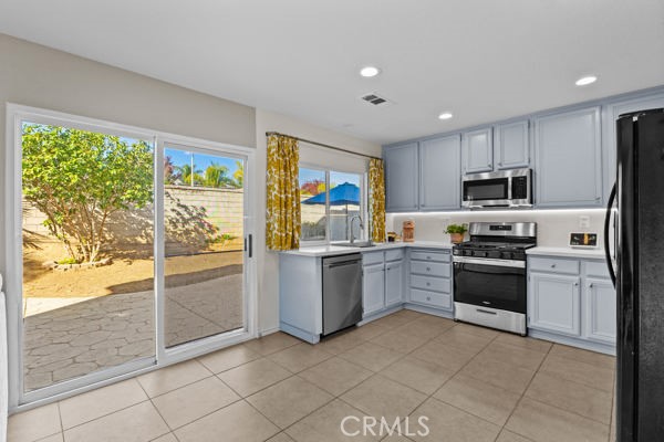 26932 St Julian Circle Murrieta, CA 92563 - Photo 13 of 37 a kitchen with granite countertop a refrigerator and a stove top oven