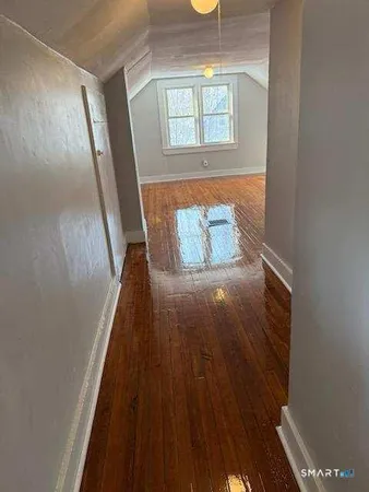 a view of a room with an empty space and wooden floor