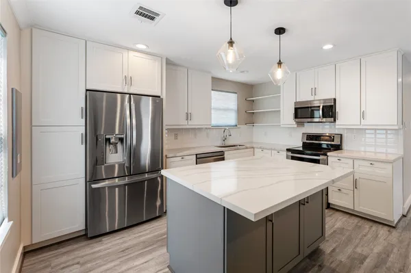 a kitchen with wooden cabinets and stainless steel appliances