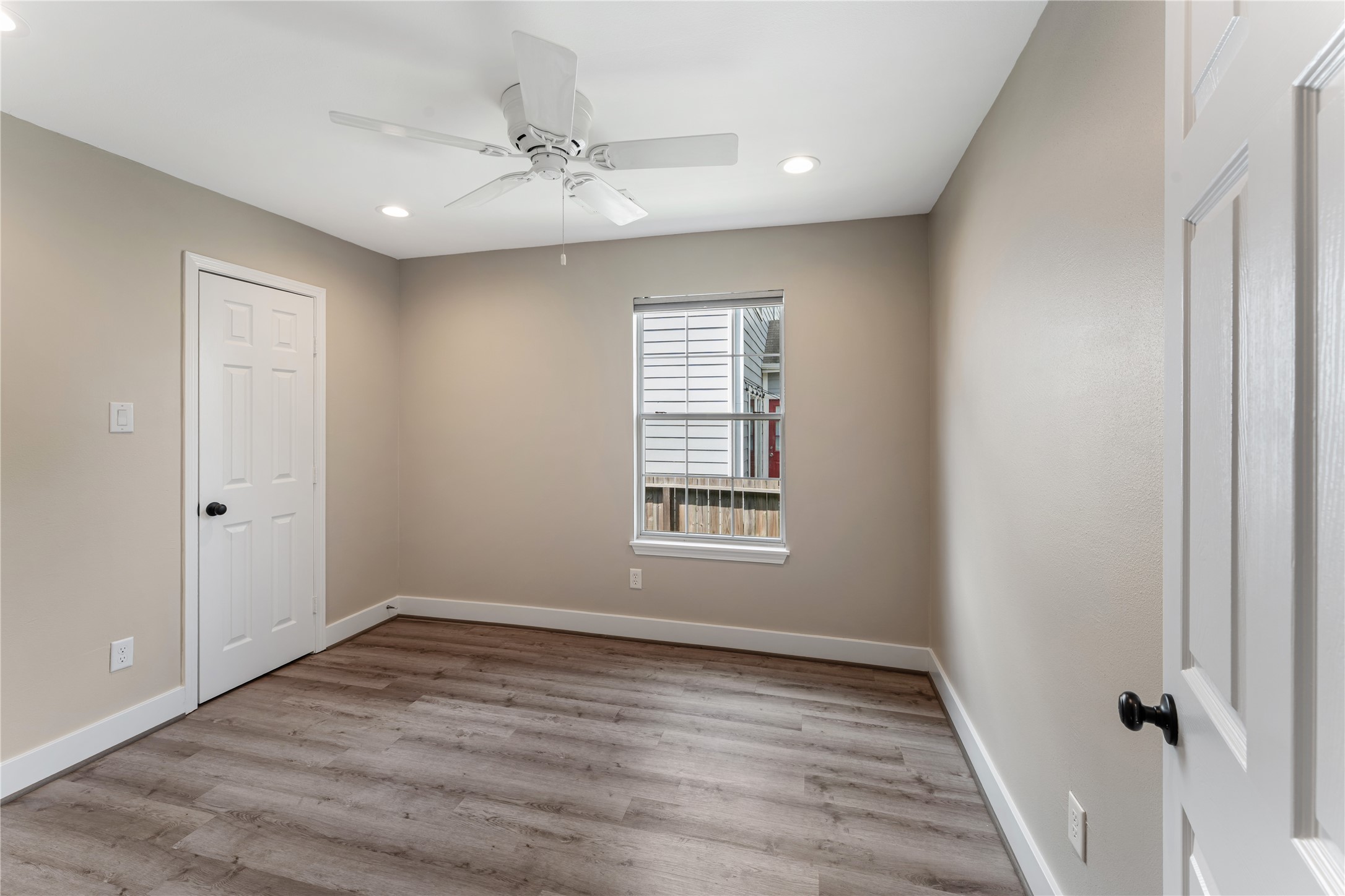809 East 40th Street Houston, TX 77022 - Photo 11 of 13 Spacious bedroom with fresh neutral paint, new flooring, and updated ceiling fan creates a comfortable retreat. Natural light fills the room, enhancing the clean and modern aesthetic.