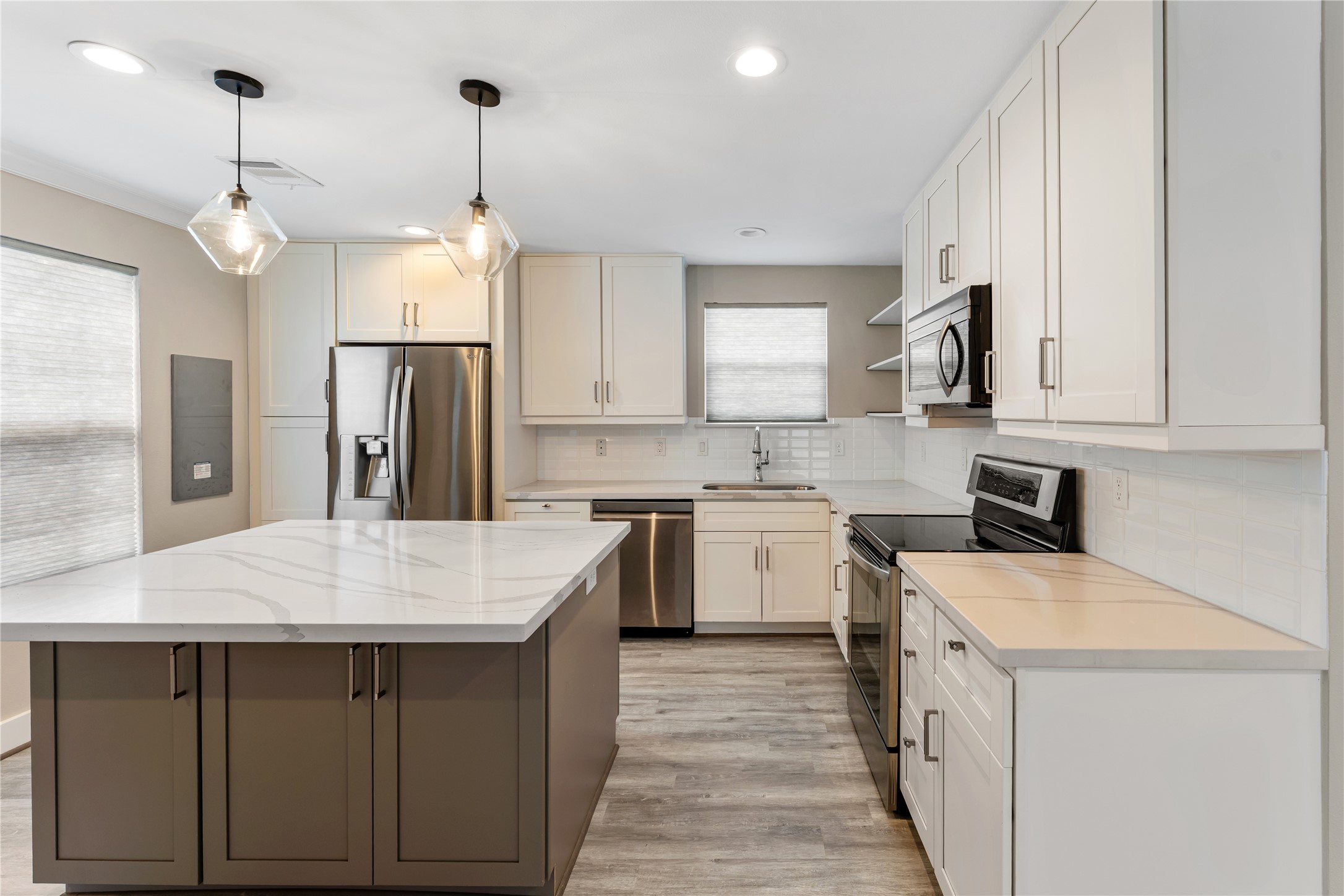 809 East 40th Street Houston, TX 77022 - Photo 4 of 13 This beautifully updated kitchen features quartz-style countertops, stainless appliances, and ample cabinetry for storage. Thoughtfully designed with modern fixtures and finishes, it flows seamlessly into the main living areas.