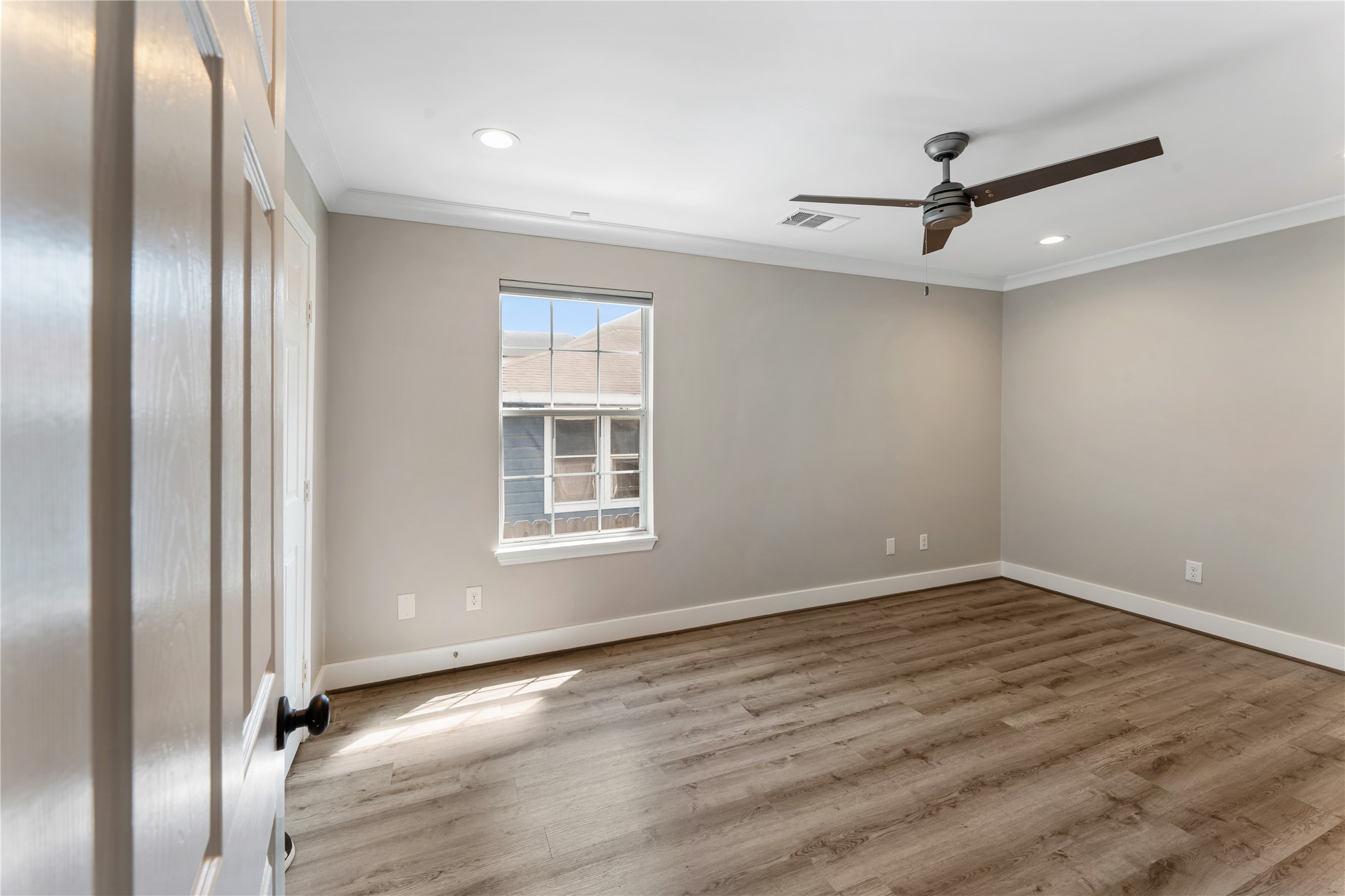 809 East 40th Street Houston, TX 77022 - Photo 8 of 13 Light-filled primary bedroom with updated flooring, neutral tones, and a ceiling fan for comfort. Clean finishes and a functional layout make this space ideal for a personal retreat.