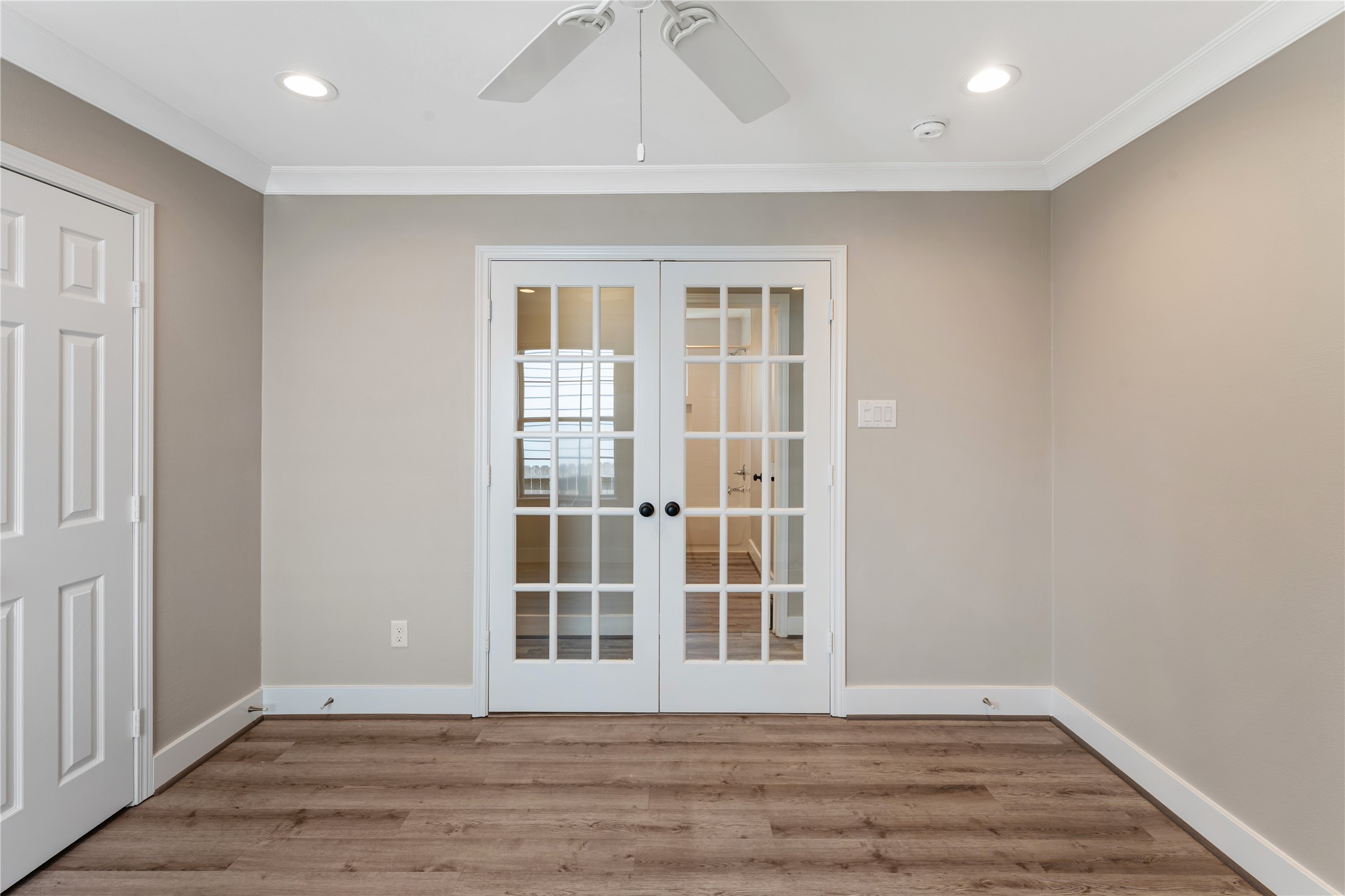 809 East 40th Street Houston, TX 77022 - Photo 9 of 13 Secondary bedroom with closet that has built-in shelving. This versatile flex space with beautiful flooring and French doors, perfect for a home office, study, or additional living area.