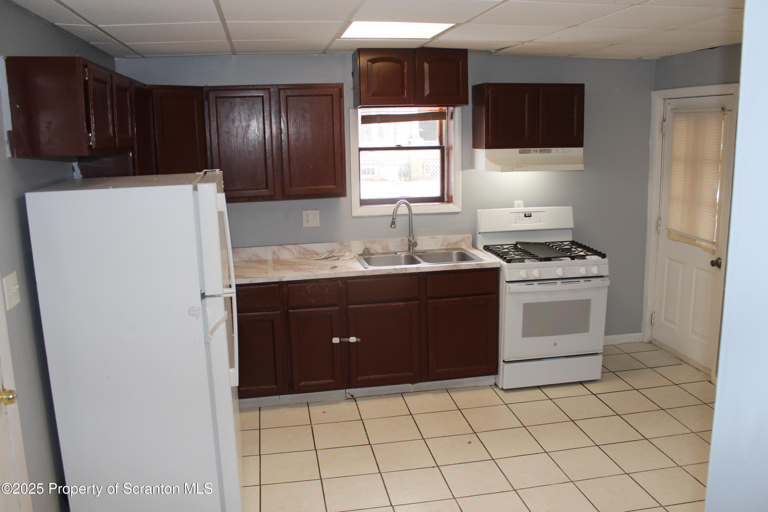 323 Union Street, Unit 1 Taylor, PA 18517 - Photo 6 of 20 a kitchen with a sink a stove and refrigerator