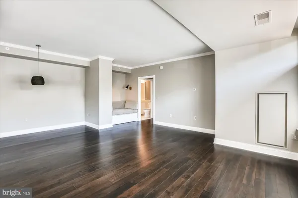a view of an empty room with wooden floor