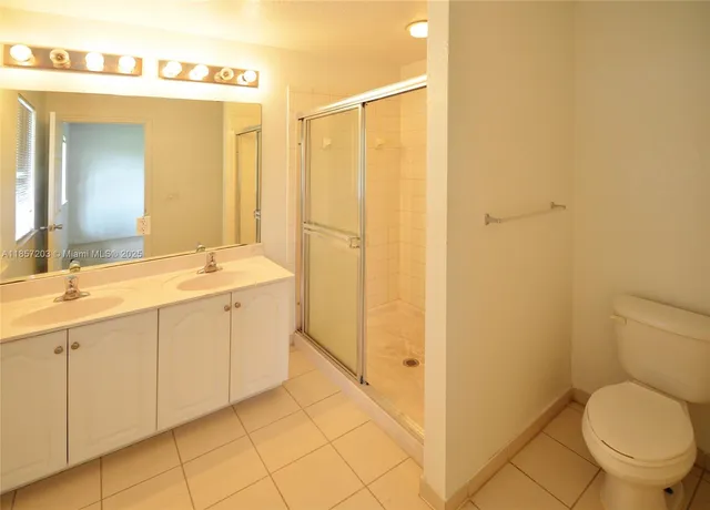 a bathroom with a granite countertop sink mirror vanity and toilet