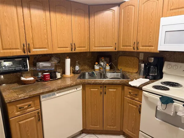 a kitchen with stainless steel appliances granite countertop a sink a stove and a microwave